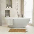 Aura Series stone resin 55" freestanding tub in a minimalist setting with built-in shelves and natural accents. |ACE DECOR