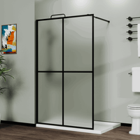 Matte black framed shower door panel with frosted glass panels installed in a modern bathroom setting, Liora Series.