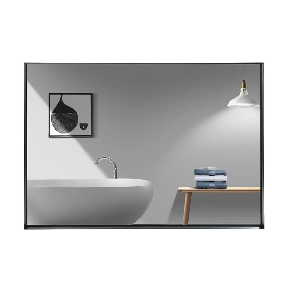 Noir Series black rectangular beveled-edge mirror reflecting a minimalist bathroom scene with a bathtub, artwork, and towel.