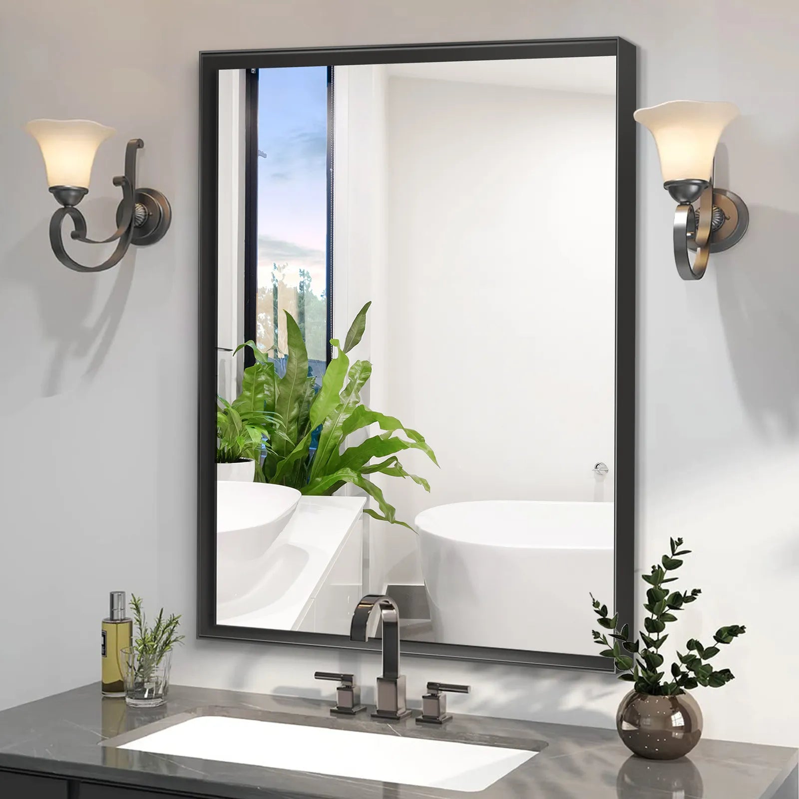 Noir Series black rectangular mirror installed vertically in a modern bathroom with vintage sconces, reflecting a bathtub and window view.