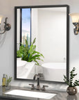Noir Series black rectangular mirror installed vertically in a modern bathroom with vintage sconces, reflecting a bathtub and window view.