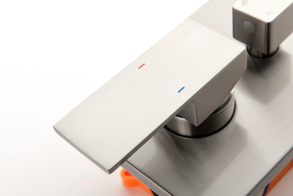 Brushed nickel shower temperature control handle with hot and cold indicators.