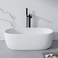 Lissome 51" solid surface freestanding bathtub in a minimalist small bathroom with white marble tile and black faucet.
