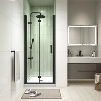 Bathroom view with matte black bi-fold semi-frameless shower door installed.