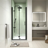 AeroFold Series 30 x 72 matte black semi-frameless bi-fold shower door installed in a modern alcove bathroom.