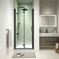 AeroFold Series 34 x 72 matte black semi-frameless bi-fold shower door installed in a modern alcove bathroom.