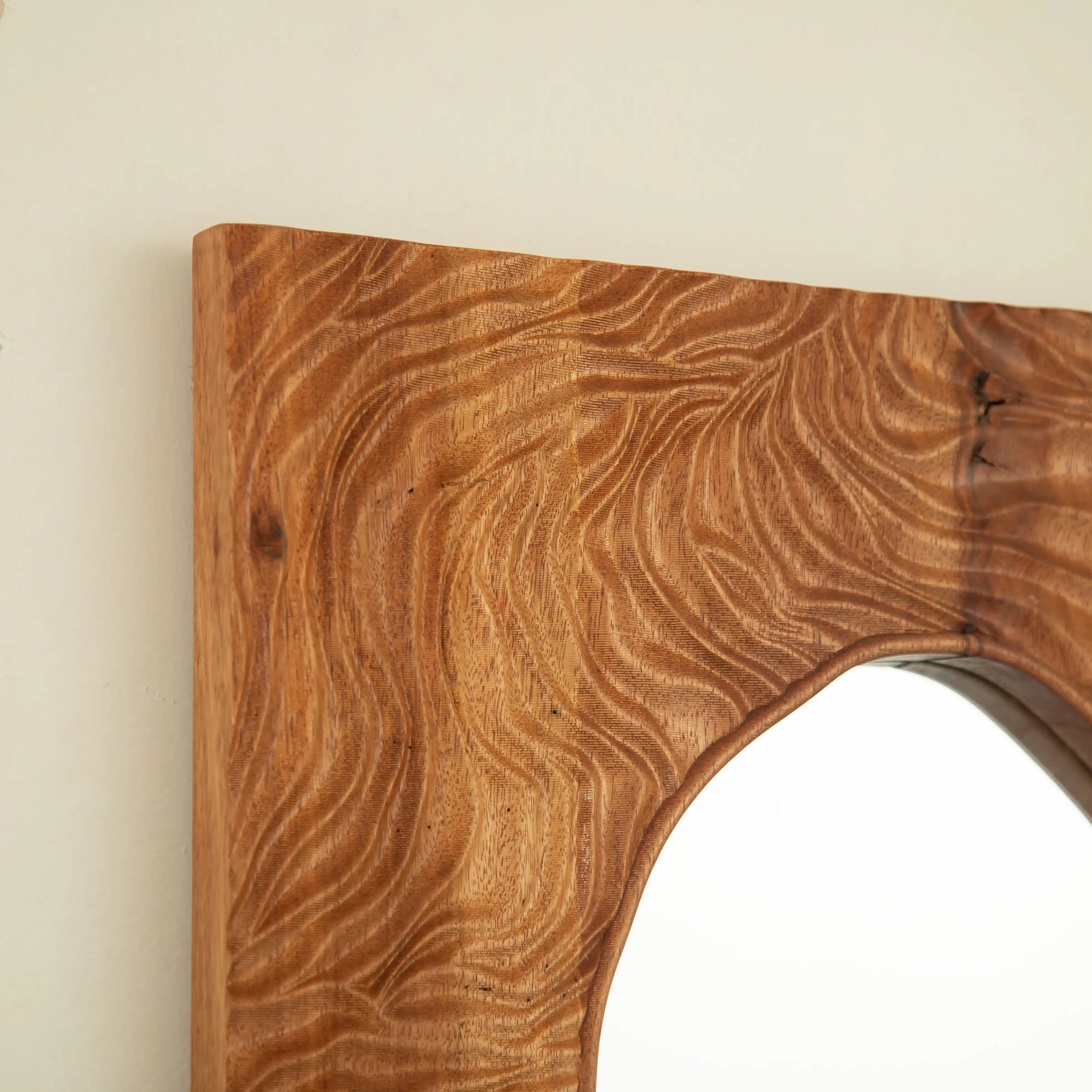 smoothly rounded rosewood corner detail on a wood vanity mirror frame.