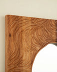 smoothly rounded rosewood corner detail on a wood vanity mirror frame.