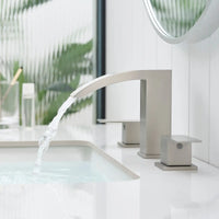 Modern waterfall bathroom faucet with sleek brushed nickel finish on white vanity countertop