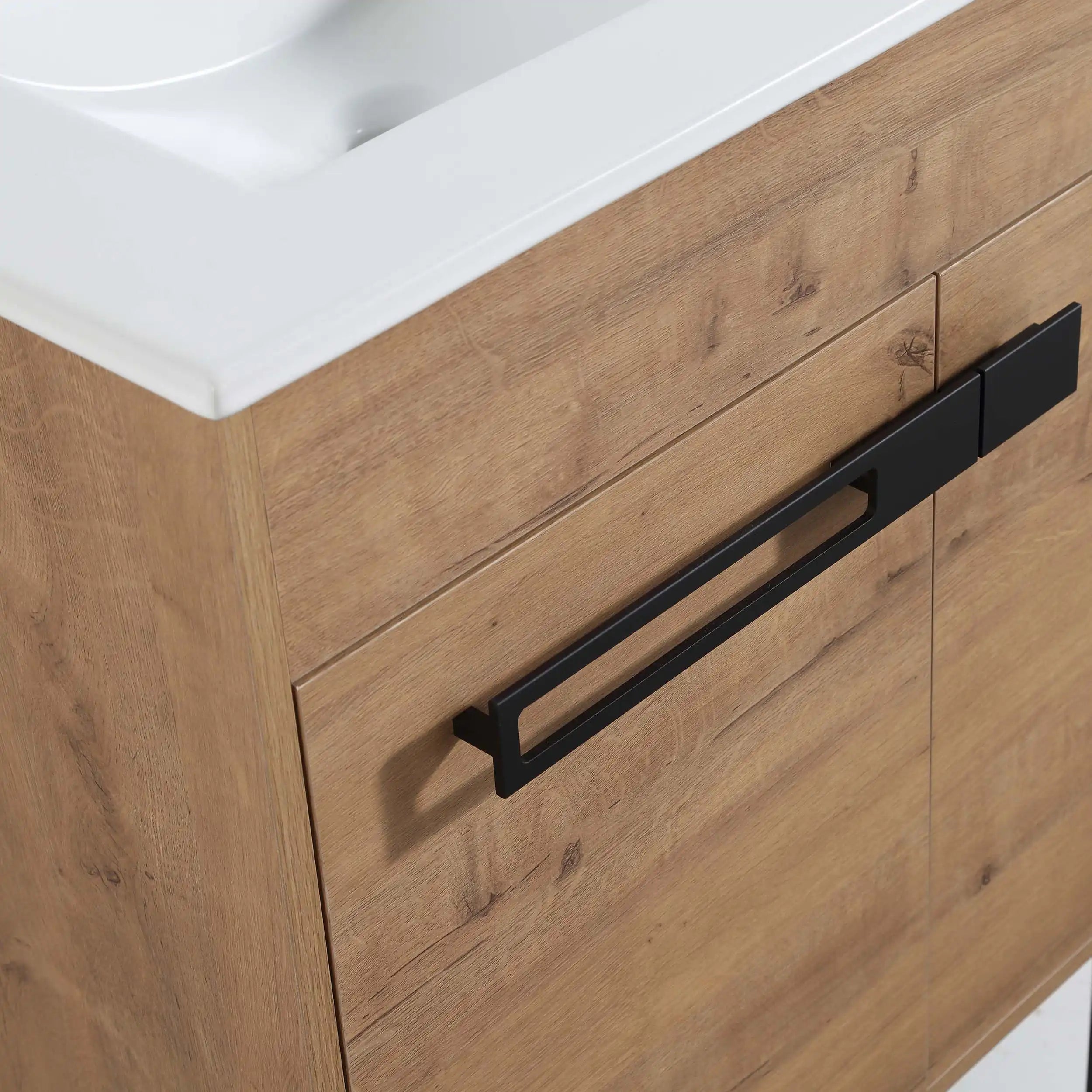 24" freestanding bathroom vanity with sink highlighting ceramic sink edge and matte black handle detail.