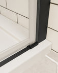 Bottom track and seal detail of matte black framed shower door on white shower base | Ace Decor