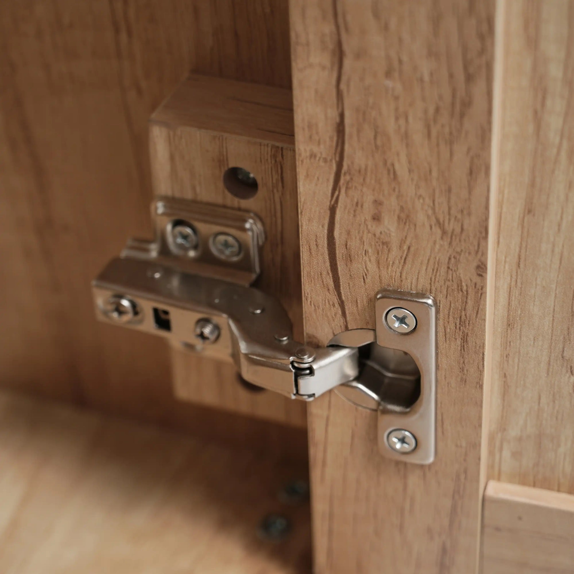 Close-up of metal hinge on bathroom vanity cabinet door, designed for smooth and silent operation | Ace Decor