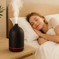 Brume portable ceramic essential oil diffuser creating calming mist beside bed for restful relaxation.