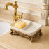 Marseille 7.5 inch European vintage double soap dish with ceramic tray, drainage holes, and ornate gold base by bathroom sink.