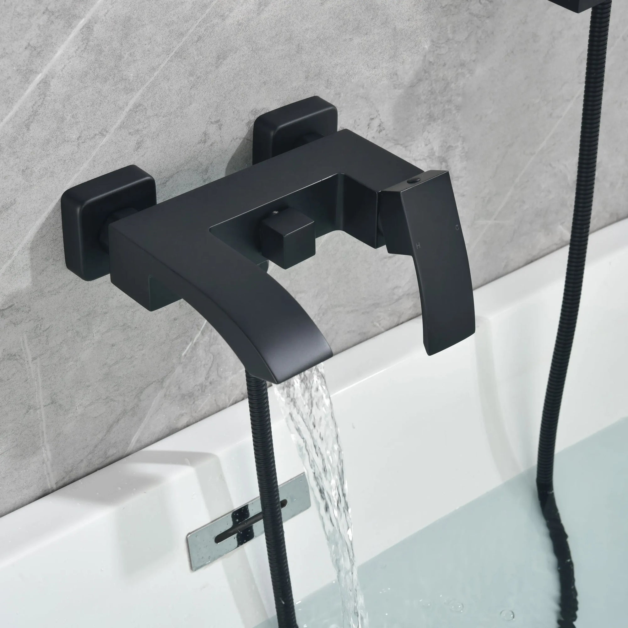 Close-up of the matte black waterfall tub spout with smooth flowing water.