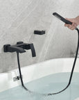 Matte black handheld shower in use for flexible bathtub rinsing.
