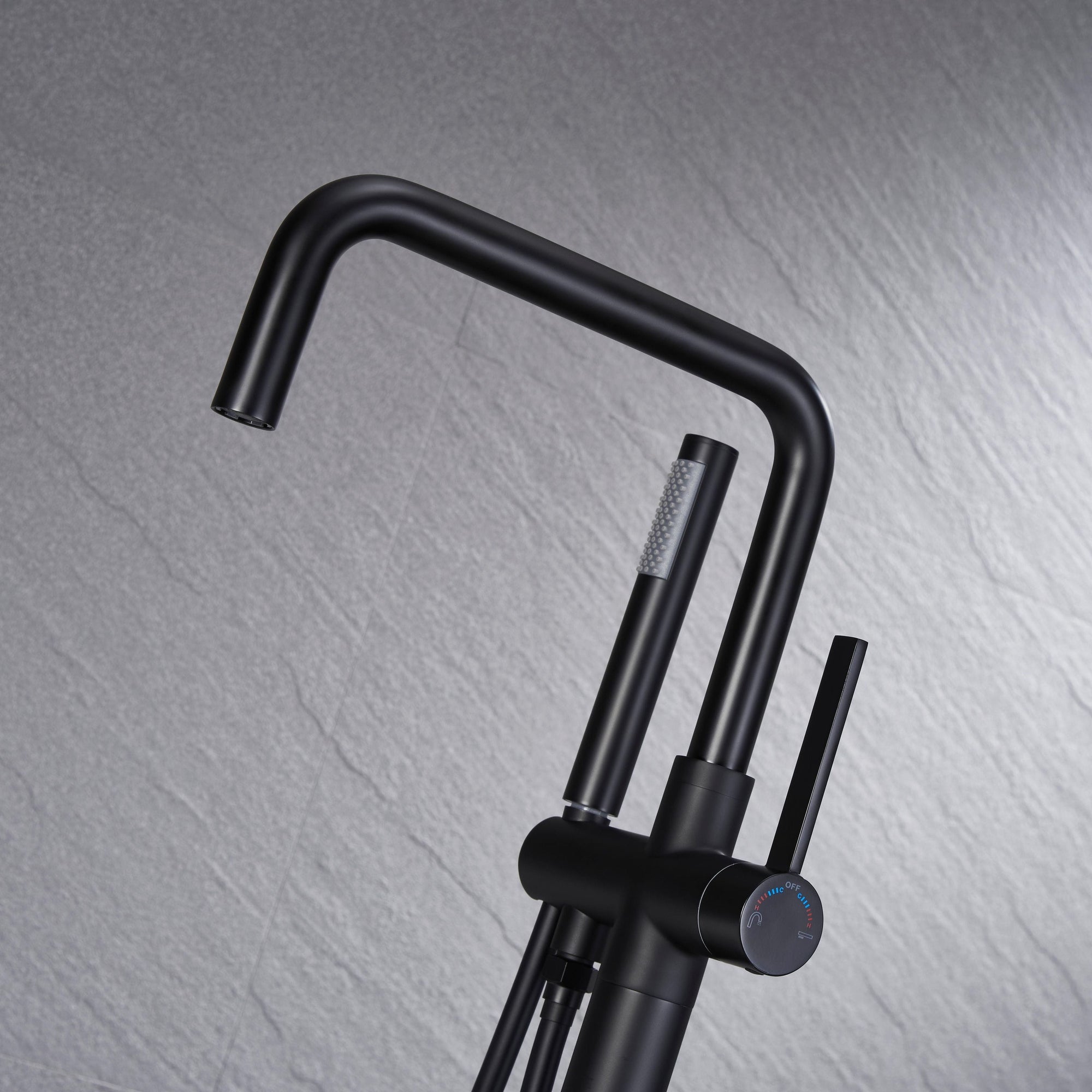 Close-up of Black Freestanding Tub Faucet spout and handheld shower, sleek matte black finish for modern bathroom design.