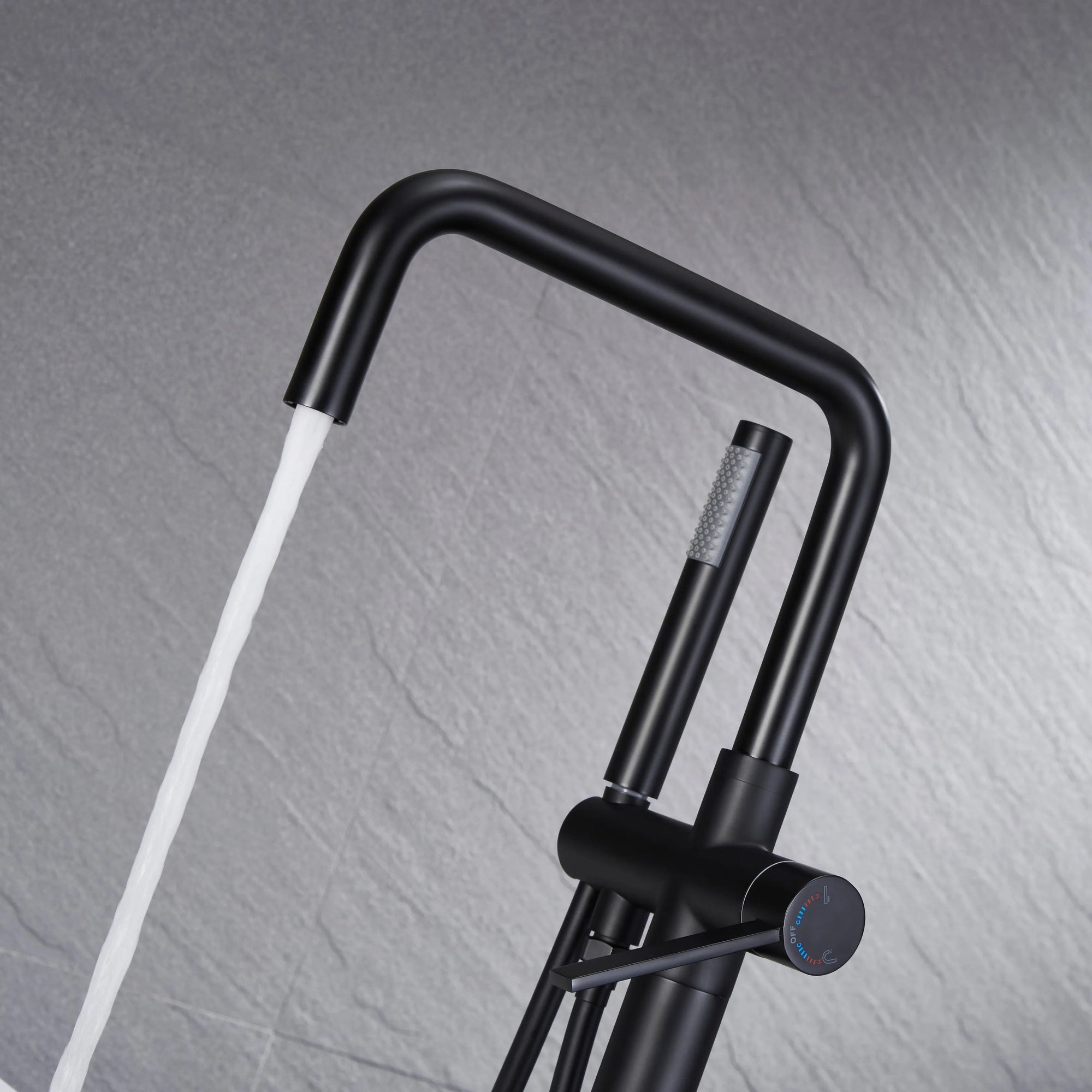 Black freestanding tub faucet spout and handheld shower with spout runing water flow.