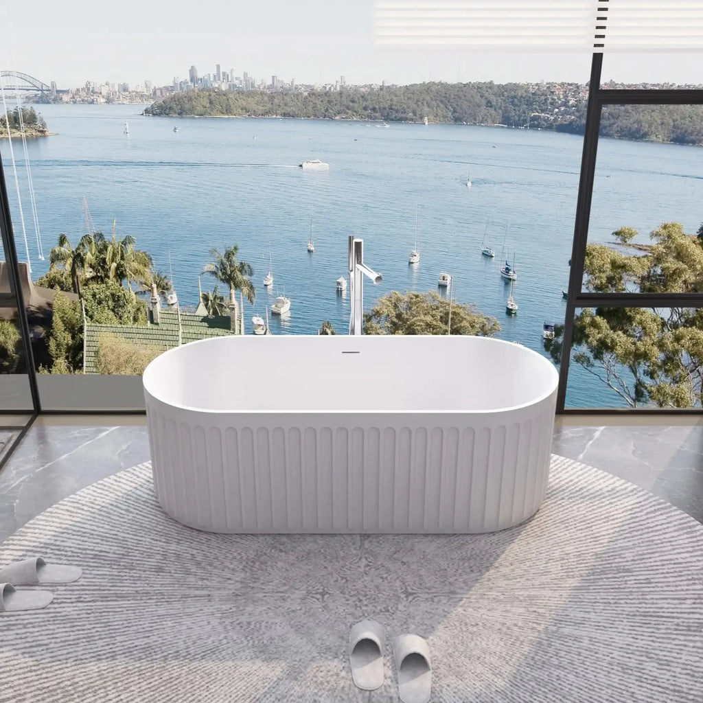 Nectar Series 67" soaking tub with circular rug and tub faucet in a minimalist bathroom featuring a panoramic harbor view.