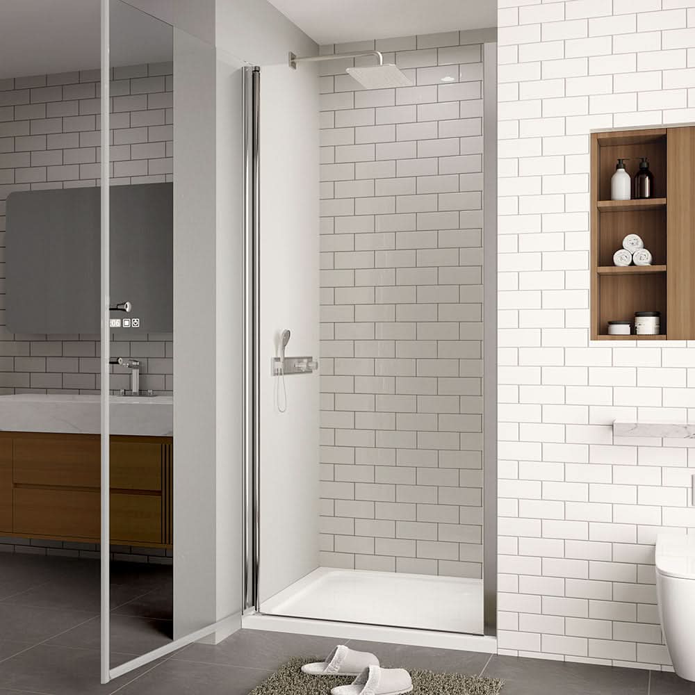Semi-frameless pivot shower door in chrome finish shown open in modern white tiled bathroom.