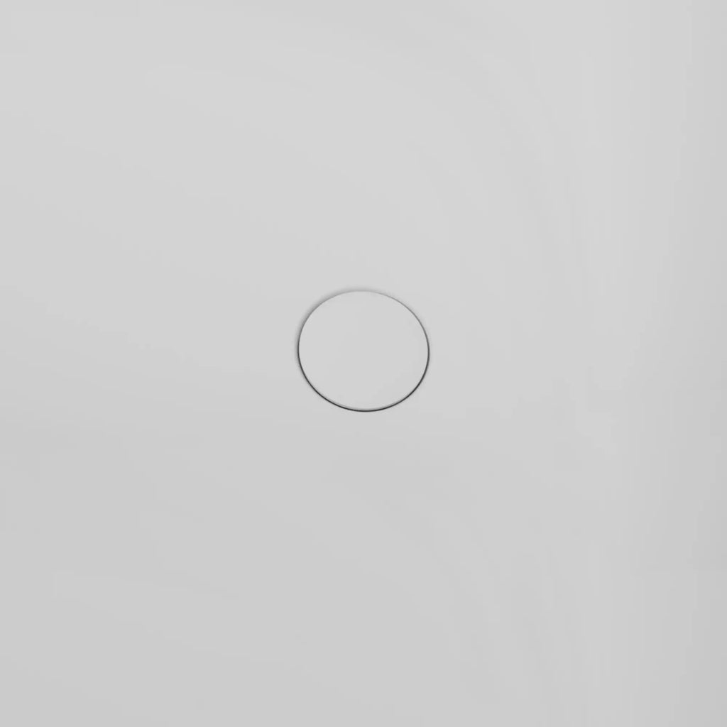 Close-up of the sleek pop-up circular drain in the white 51" solid surface soaking tub, minimalist design.